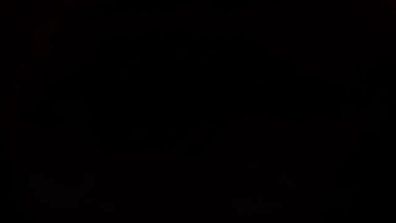Mouth In: The camera pushes into an open mouth and through into darkness.